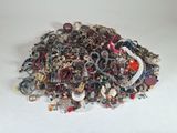 a pile of assorted jewelry on a white surface
