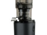 un extracteur de jus noir posé sur une surface blanche