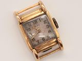 an image of a gold watch on a white surface