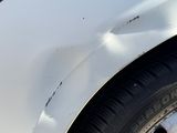 a close up of a car ' s front bumper with a denting on it