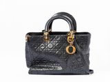 a black handbag with gold hardware on the handles