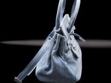 denim bag on a black table with a black background