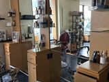 une photo d'un salon de coiffure avec de nombreux fauteuils