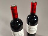 two bottles of wine sitting next to each other on a table