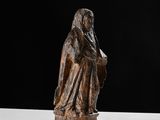an old statue of a woman holding a book on a table