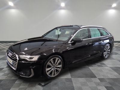 L'Audi noire est garée dans une grande pièce au sol carrelé.