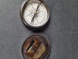 a compass and a coin sitting on a table
