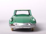 a green toy car with a white top on a white surface