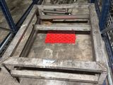 une table en métal recouverte d'un tapis rouge, dans un entrepôt