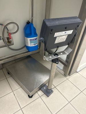 une machine posée par terre à côté d'un conteneur bleu