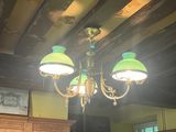 a chandelier with three green lamps hanging from the ceiling