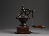 an old coffee grinder with a wooden handle on a grey background