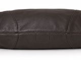 the large brown leather bag is on a white surface
