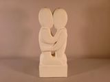 une sculpture blanche représentant deux personnes qui s'étreignent