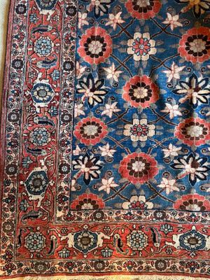 an oriental rug on a wooden floor with a cat sleeping on top of it