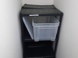 a black shelf with two plastic bins on top of it
