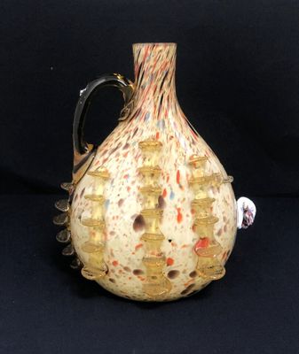 a glass vase with a handle on a black background