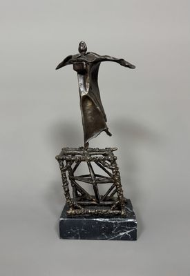 une statue représentant un homme debout au sommet d'une structure métallique