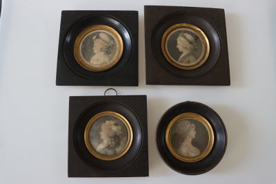 trois portraits encadrés représentant un homme et une femme, posés sur une table blanche