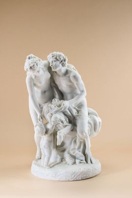 une photo représentant une statue de deux hommes et d'un chien posée sur une table