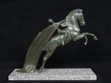 statue of a horse with a long mane and a cape on its back