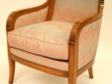 une image représentant une chaise en bois dont l'assise est rembourrée et ornée d'un motif