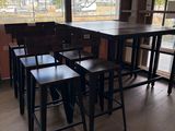 des tables et des tabourets devant une grande fenêtre dans un restaurant