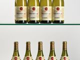 several bottles of wine are lined up on a glass shelf