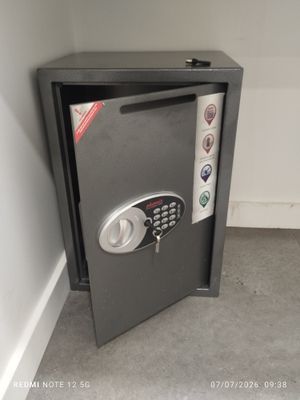 a safe box with a key on it in the corner of a room