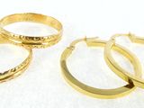 three pairs of gold hoop earrings on a white background