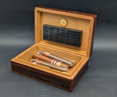 deux cigares dans une boîte en bois posée sur une table