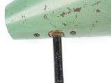 a close up of a green lamp on a metal pole