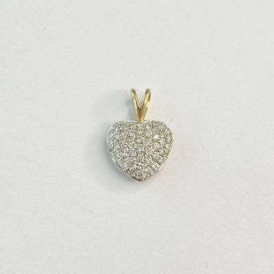 un gros plan d'un pendentif en forme de cœur en diamant posé sur une surface blanche