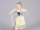 une figurine représentant une femme tenant un bâton