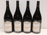 four bottles of wine are lined up on a table