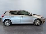 the silver car is parked in a large room with a white wall