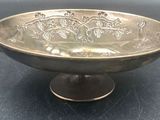 a large metal bowl with handles on a black surface