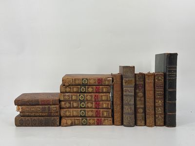 several old books stacked on top of each other on a white surface