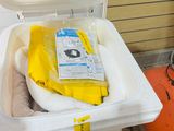 a white trash can with a yellow bag inside of it