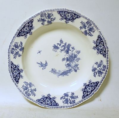 une assiette bleue et blanche ornée d'un oiseau et de fleurs