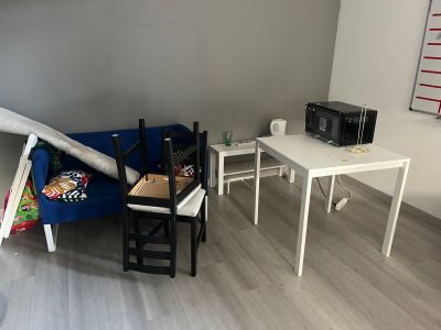 un canapé bleu dans une pièce où se trouvent une table et un micro-ondes