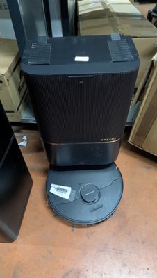 a black speaker sitting on top of a table next to boxes