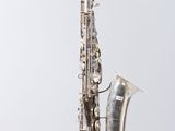 an image of a silver saxophone sitting on top of a white surface