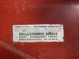 a sign on the side of a red tractor