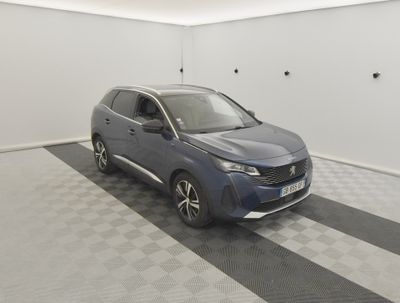 Une voiture bleue est garée dans une pièce blanche au sol à carreaux.