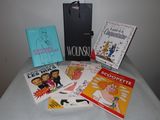 a lot of books on a table with a bag