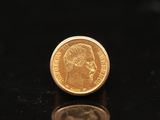 une pièce d'or posée sur une surface noire