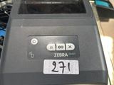 une imprimante Zebra posée sur une table en verre