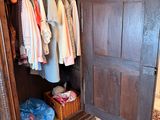a large wooden cabinet with many clothes on it