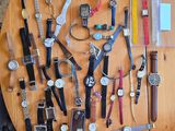 une table sur laquelle sont posées de nombreuses montres et d'autres objets